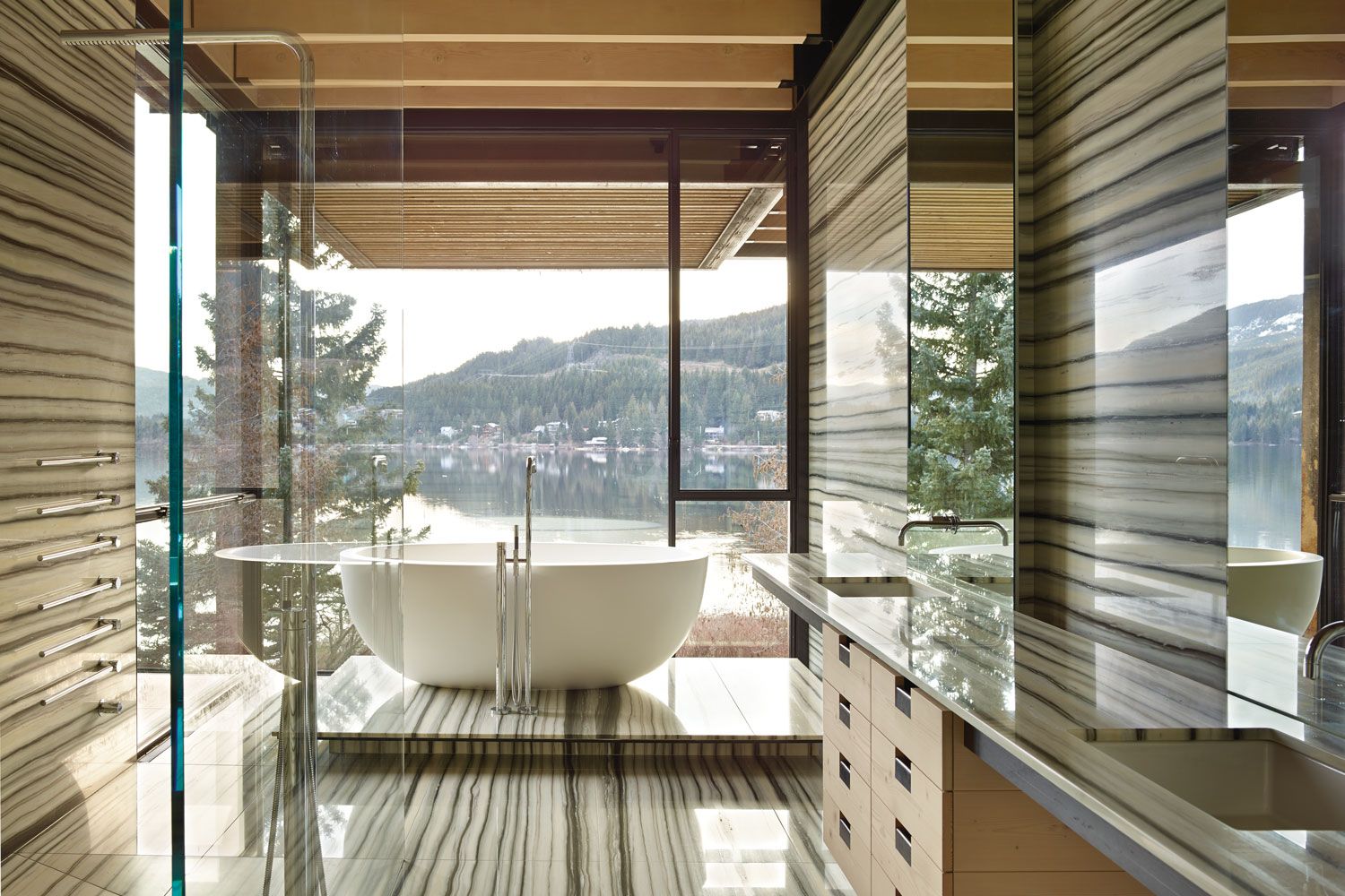Designed by Tom Kundig of Olson Kundig, the master bath of this Whistler, Canada, ski house masterfully brings the outside in with its Zebrino marble by Marble Art and local wood from fir trees.