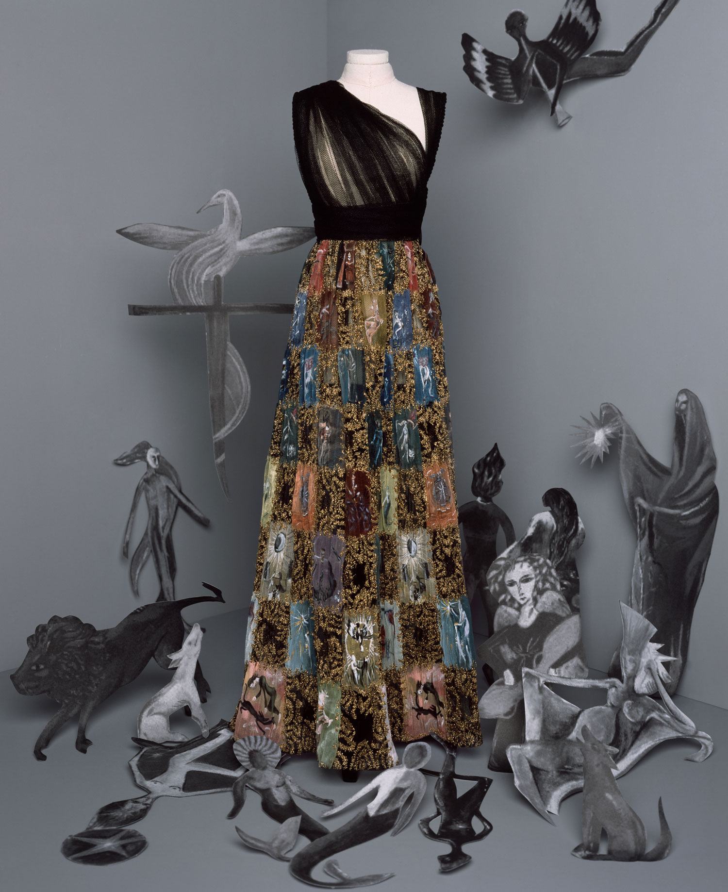 Dior’s Esphyr Look: Long black tulle dress. Asymmetrical draped bodice and skirt embroidered with a multicolored chiffon checkerboard painted with a Leonora Carrington “Tarot” motif highlighted with gold thread.