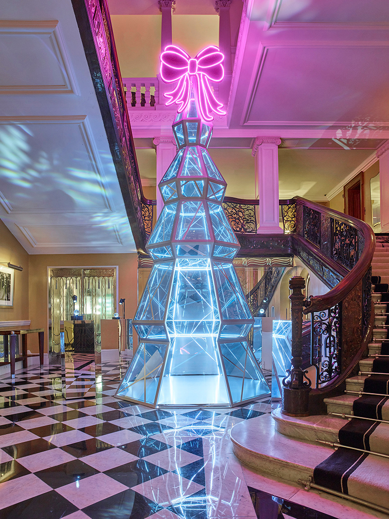 Two people walk past the holiday window display at the Dior store