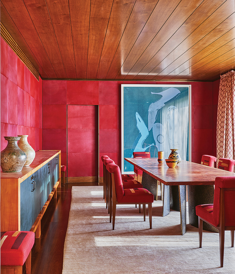 An Andy Warhol diamond dust painting pops against Moroccan red-leather panels in the main-floor dining room, where Marino designed the table with an African bubinga wood top and hammered-bronze legs; the vintage sideboard is by Jacques Quinet.