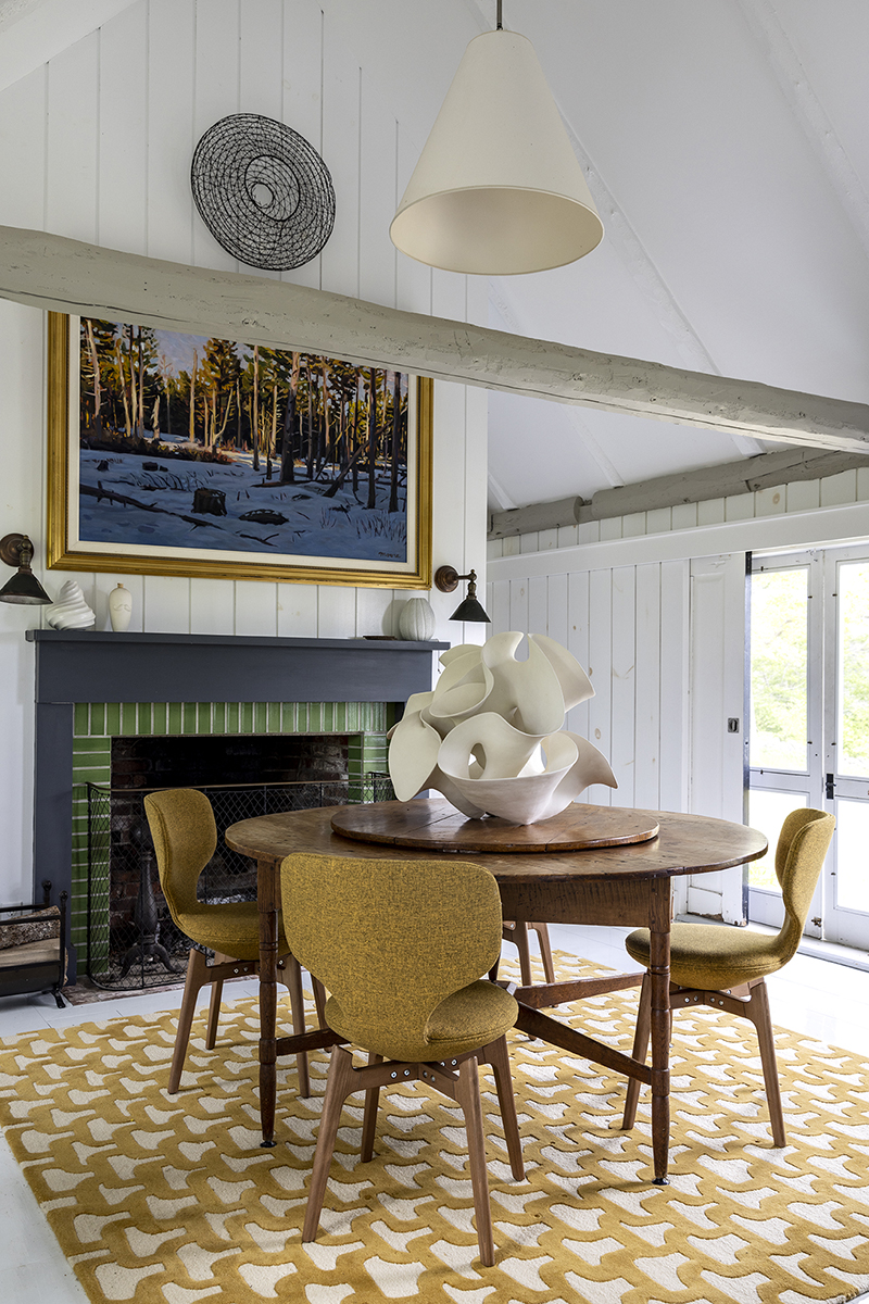 The dining area’s upholstered chairs and rug feature matching mustard hues.
