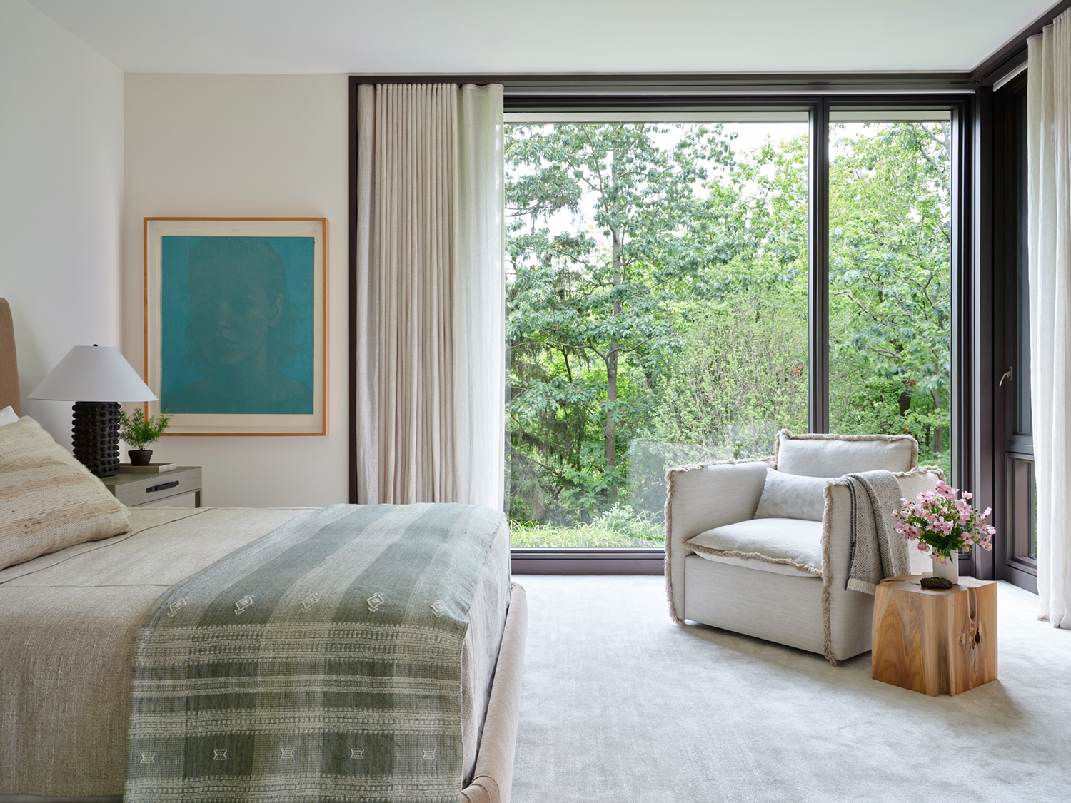 A blue canvas by Swiss painter Franz Gertsch hangs in the primary bedroom, which features a lounge chair and lamps by Formations, Joseph Jeup nightstands, and a bed by A. Rudin in the renovation completed by Robbins Architecture