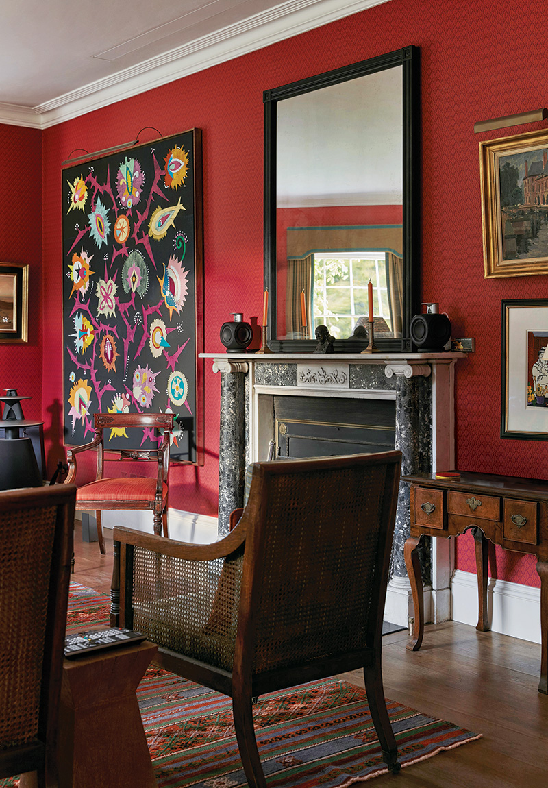 A Cole & Son wallpaper enlivens the study, which Ben Pentreath outfitted with a custom ebonized mirror above the fireplace and an array of antiques, including a George II lowboy owned by the clients.