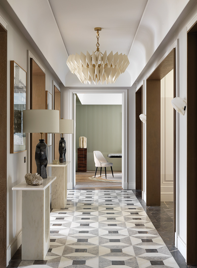 A geometric- patterned floor in marble and granite lines the entrance hall, where a painting by José Loureiro is displayed above a Damien Langlois-Meurinne marble table.