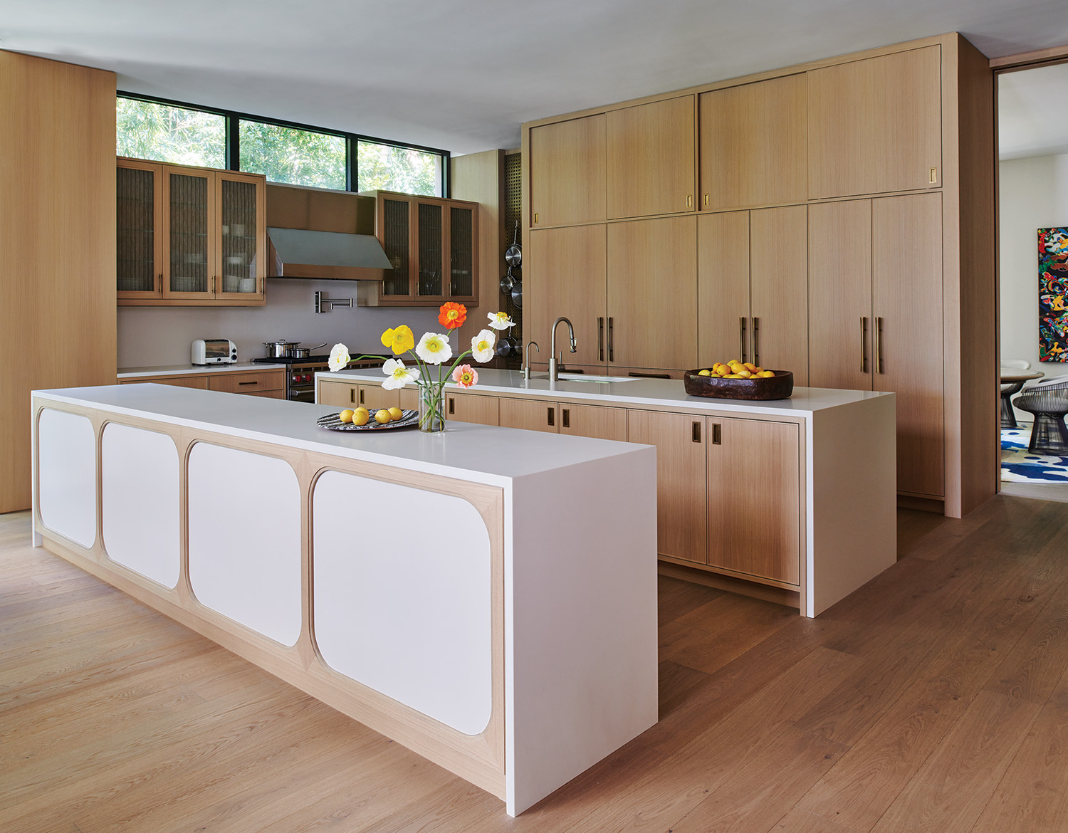 Kitchen outfitted with white oak cabinetry, Lapitec from ABC Stone countertops, and Waterstone sink fixtures, in this renovation by William T. Georgis.