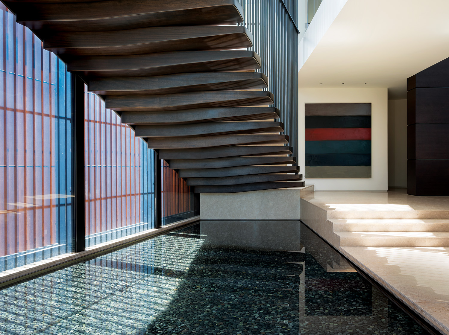 Magni Kalman Design’s James Magni and Jason Kalman conceived this floating stairway in Los Angeles with interior rails that mirror the exterior louvers to create a stunning shadow effect. The water feature extends from the outside in, and the artwork is by Sean Scully.