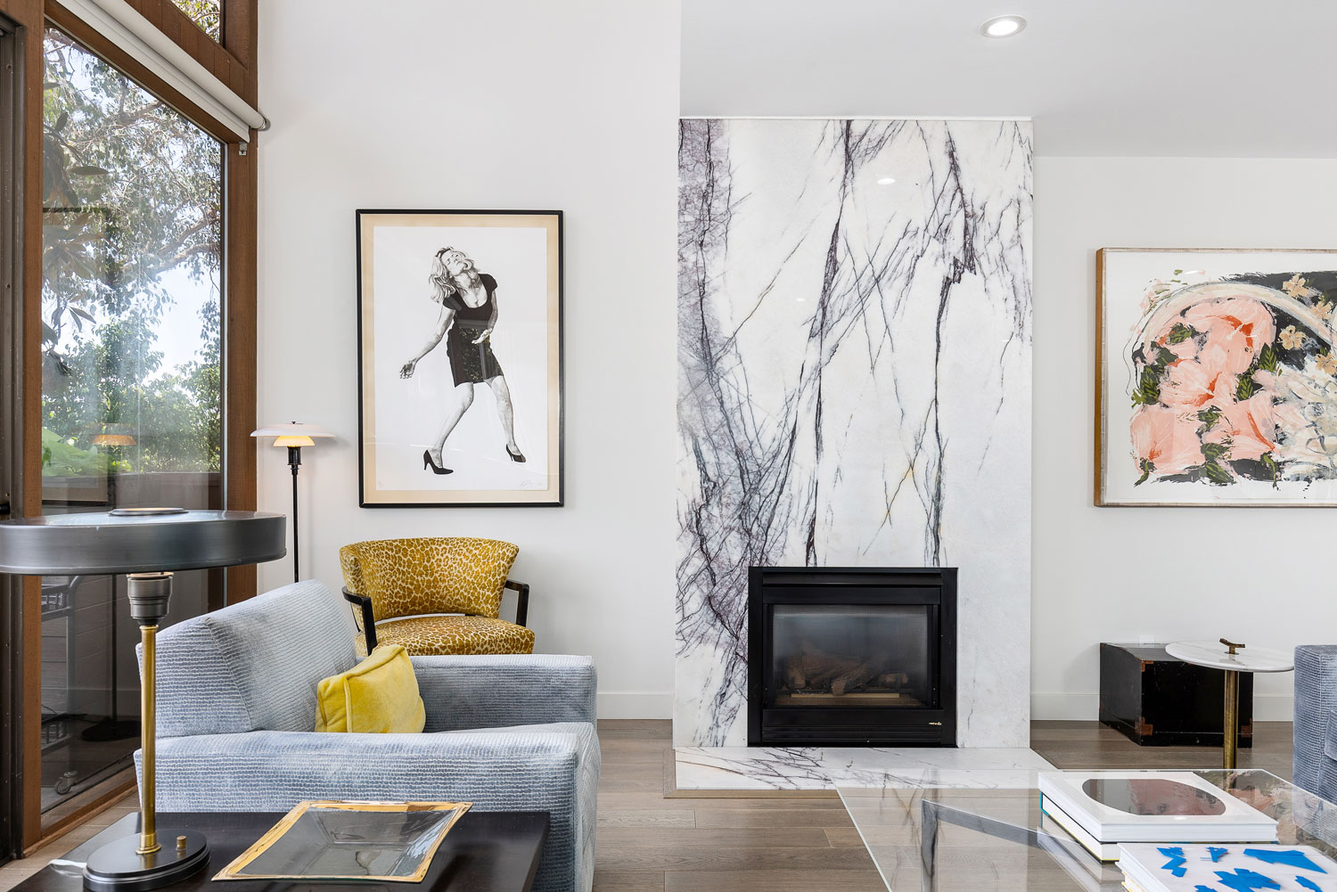 The home, formerly lived in by Richard Holme, protégé of Richard Neutra, features a dramatic gas fireplace with floor to ceiling marble.