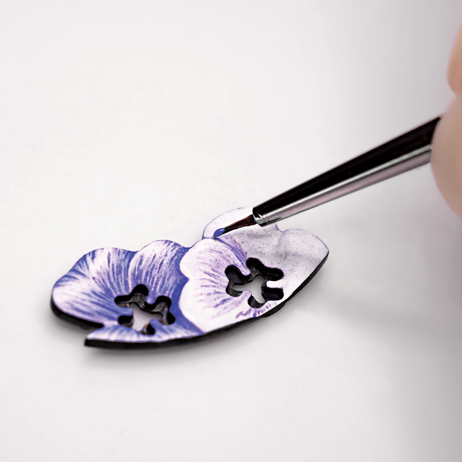 For the Lady Arpels Brise d’Été by Van Cleef & Arpels, the precise application of layers of enamel forms the subtle gradation of color in the petals.