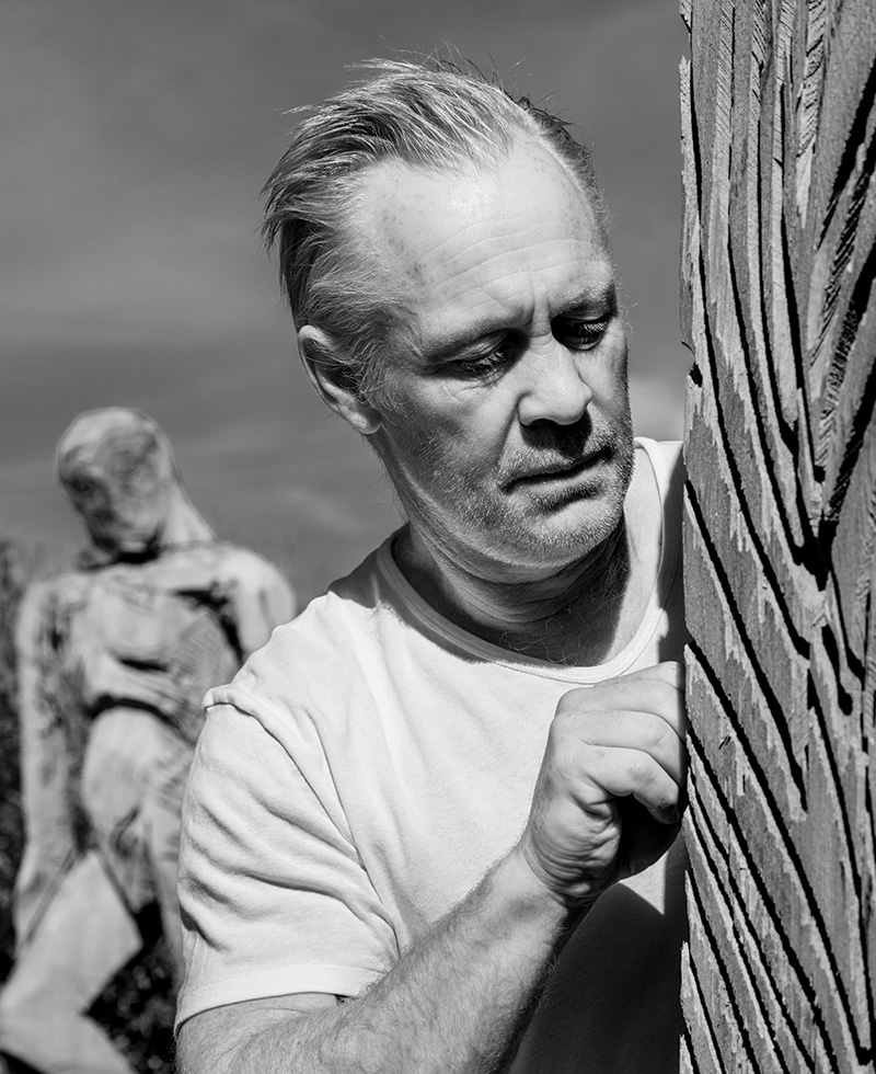 At his outdoor studio in Malibu, California, Thomas Houseago works on one of his recent sculptures carved from redwood.