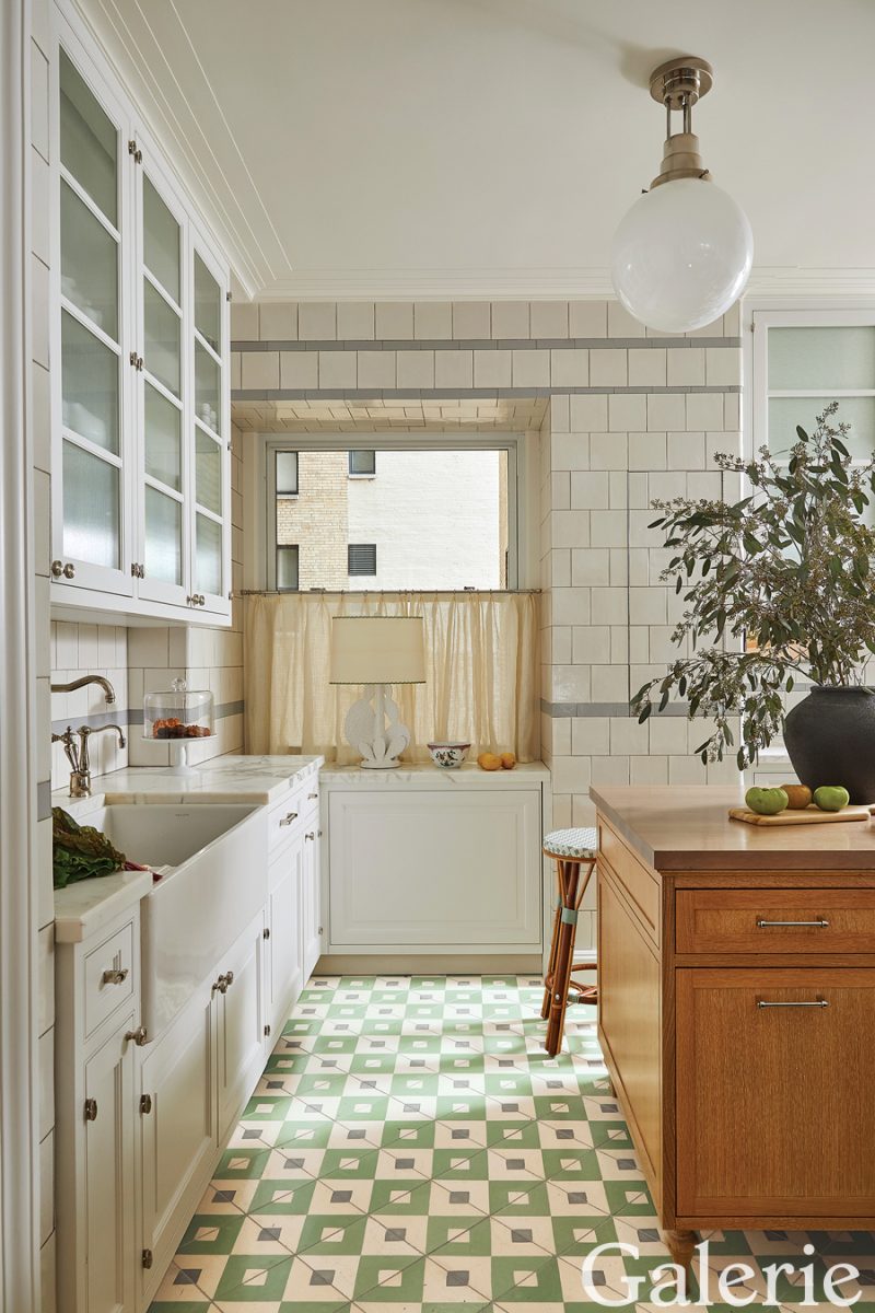 Frank De Biasi devised custom cabinetry for the kitchen and designed geometric tiles for the floor; the light fixture above the island is by Woka Lamps Vienna.