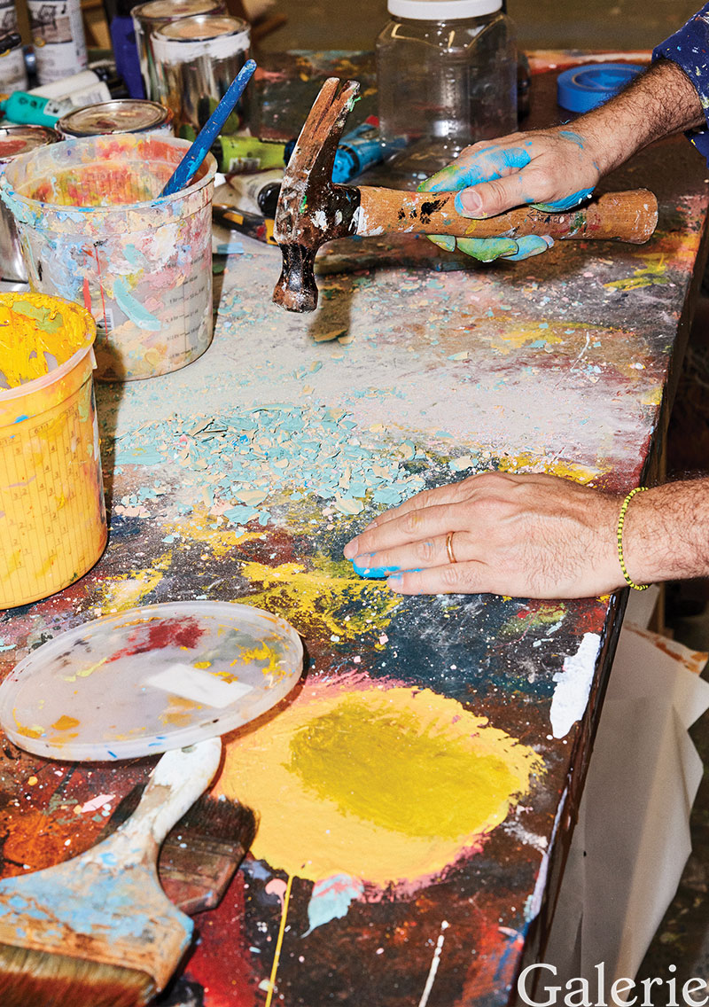 The artist breaks up bits of plaster that he will incorporate into his artwork.