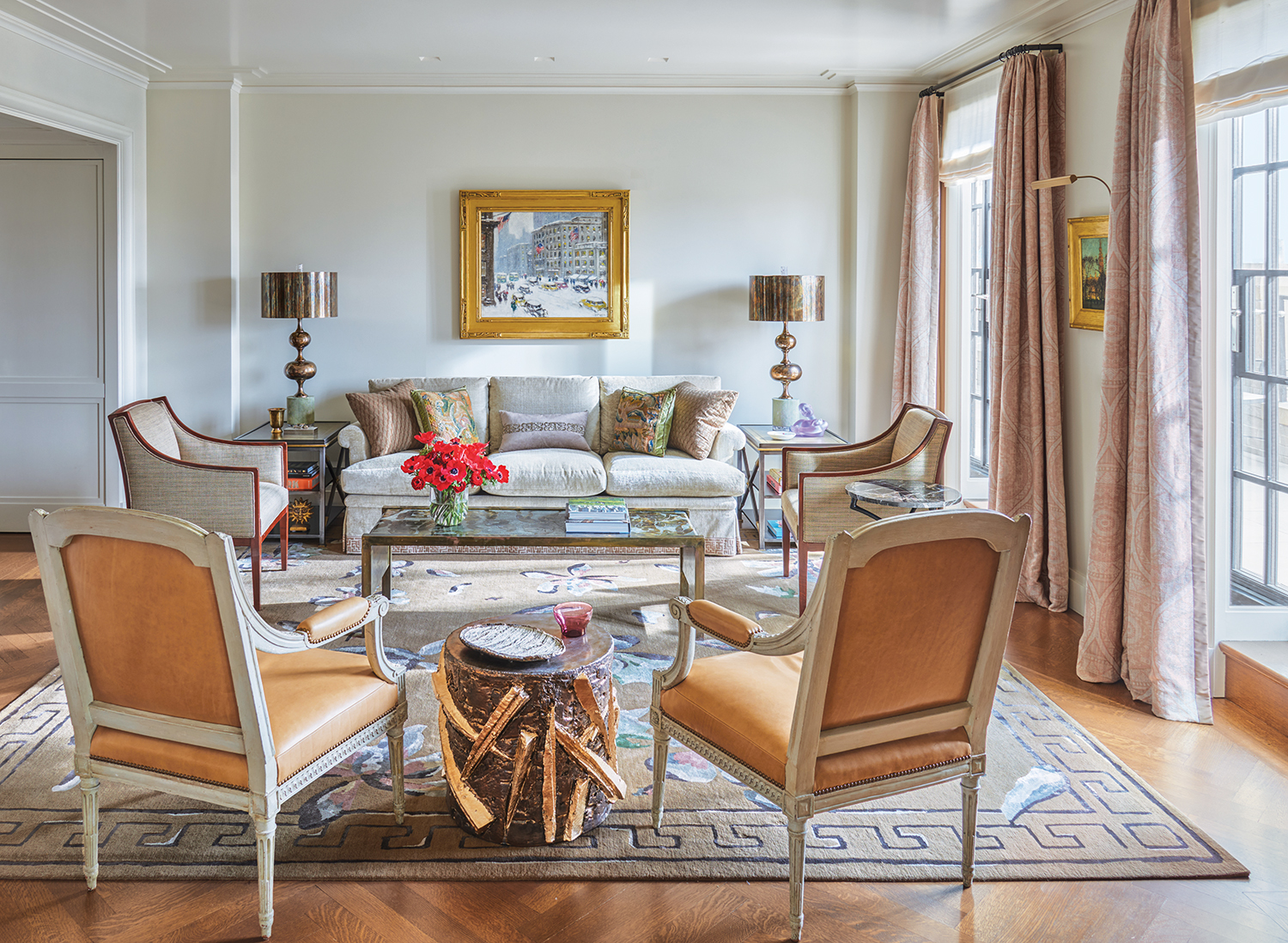 In the living room of an apartment that architect Lee Ledbetter designed for an art-collecting couple at The Carlyle hotel in New York, a Guy C. Wiggins painting overlooks a custom sofa flanked by 1940s French lounge chairs and a ’60s Philip and Kelvin LaVerne cocktail table. They are joined by brass lamps by Sylvan S.F., Louis XVI armchairs by Claude II Sene, and a Peter Lane ceramic drum table. A Paul Cornoyer painting hangs between the French doors, which are curtained in a Cowtan & Tout fabric.