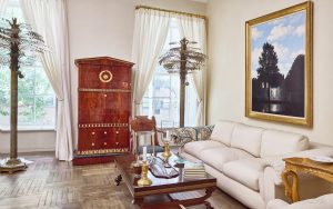 A Pair Of Large French Brass Palm Trees Attributed To Maison Jansen, A German Ormolu-Mounted And Bronzed Mahogany Secretaire circa 1815-1820, and René Magritte’s L'empire des lumières 1954) in Mica Ertegun's New York townhouse.