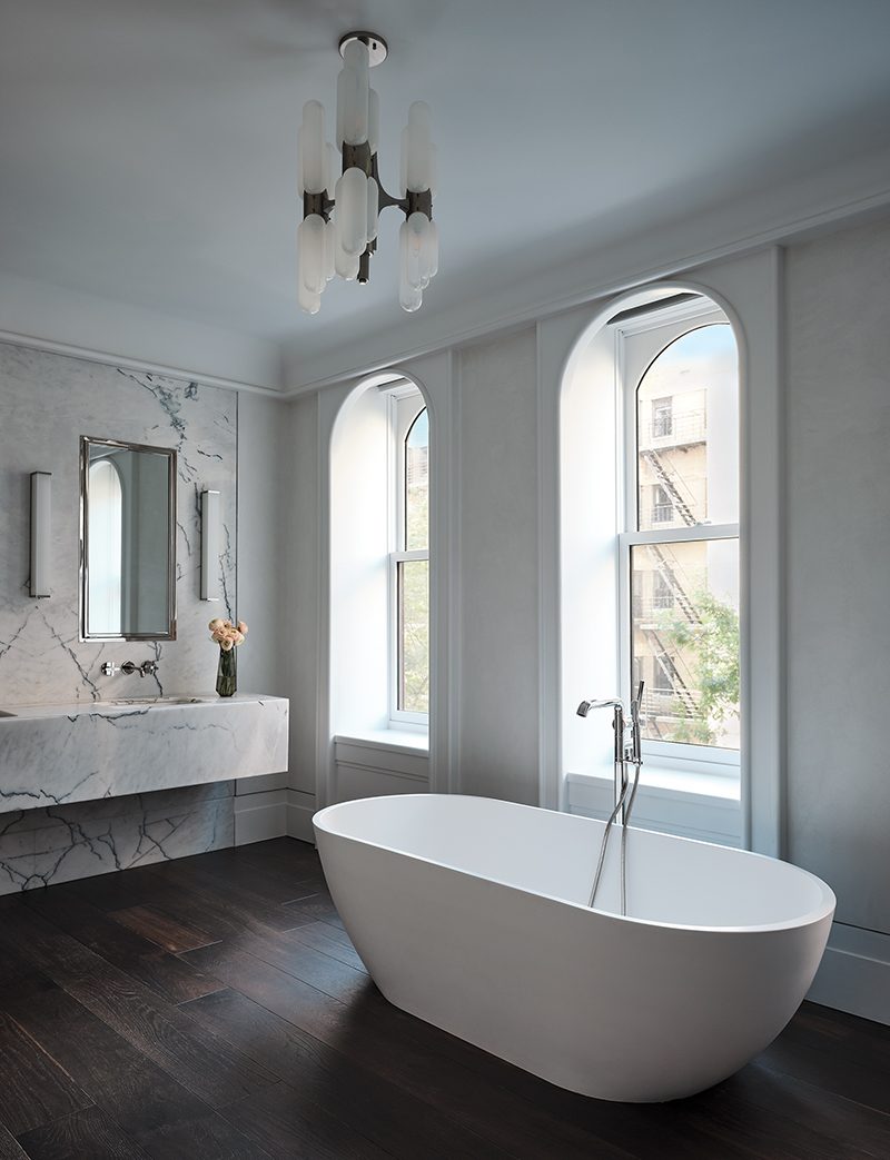 A vintage light fixture is suspended over the Antonio Lupi freestanding tub in the main bath.