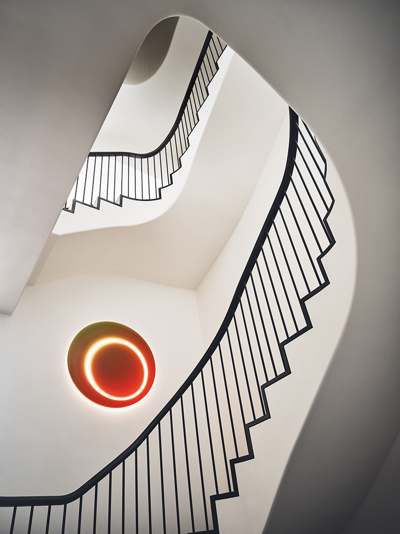 A custom Sabine Marcelis light fixture punctuates a sweeping stair.