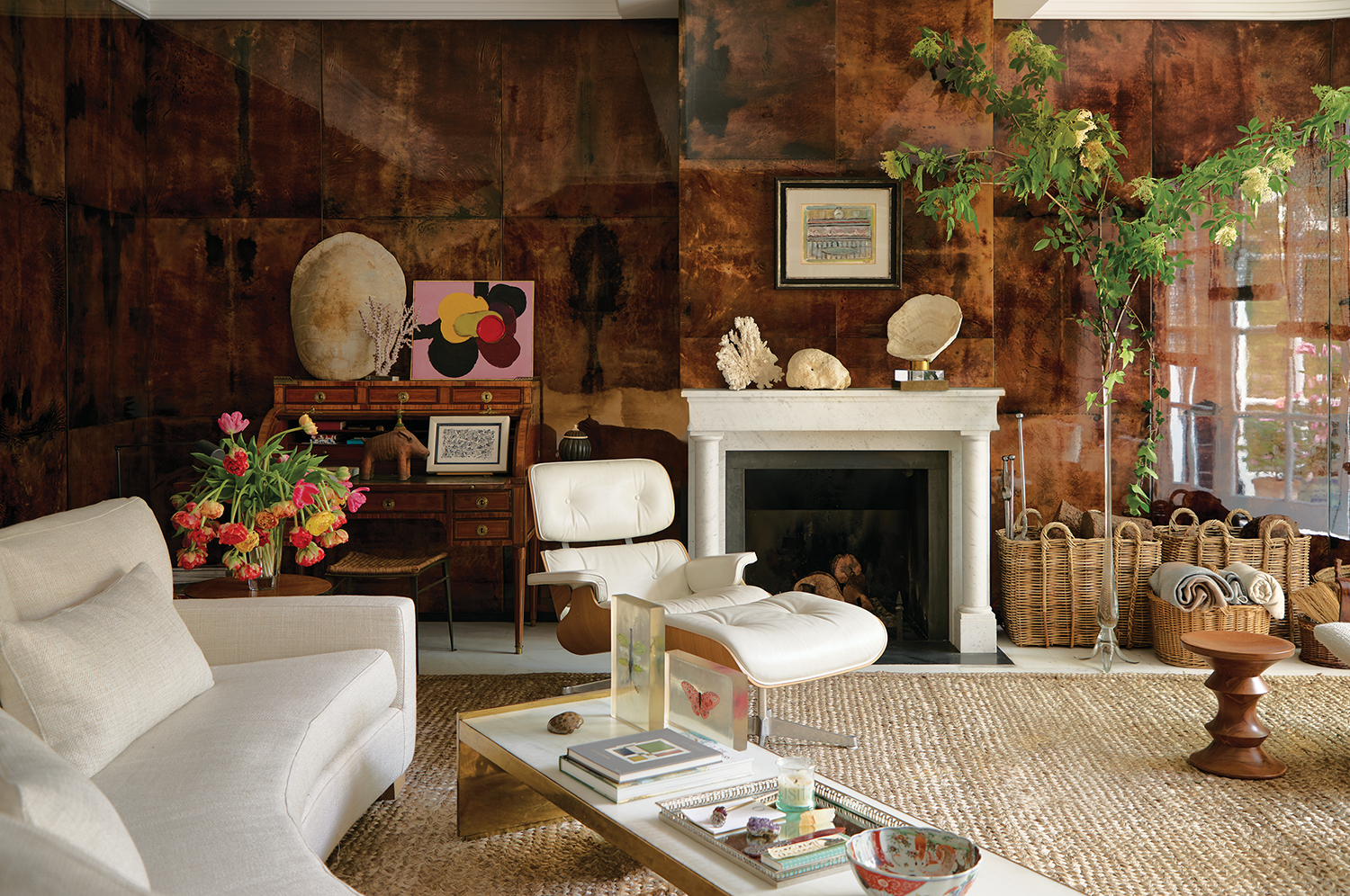 For her own living room in Madrid, designer Isabel López-Quesada juxtaposed 1960s Aldo Tura tortoiseshell panels with a custom white fireplace with clean lines and artwork by Francisco Bores and Luis Feito (left).