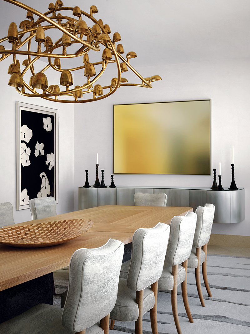 A Frederik Molenschot chandelier from Carpenters Workshop Gallery spirals above the bespoke table and Artistic Frame chairs in the dining room, where Schuster hung artworks by Alex Katz and Scott Lyall, the latter above a custom floating sideboard; the rug is by Makrosha.