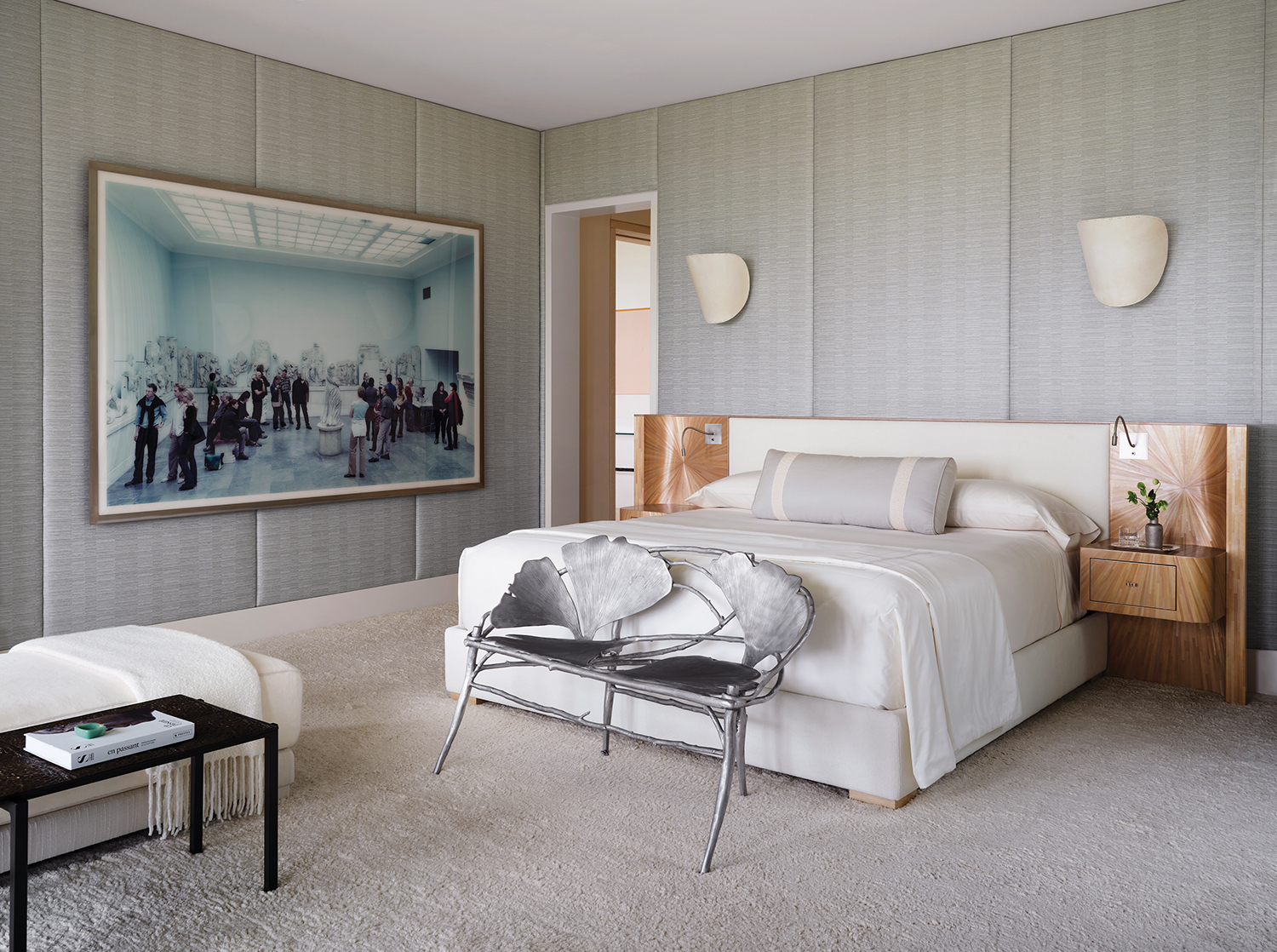 Mounted on the primary bedroom’s walls, covered in a Toyine Sellers fabric, a Thomas Struth photograph and Mauro Fabbro sconces overlook an Alexander Lamont bed. A Claude Lalanne bench stands at the bed’s foot.