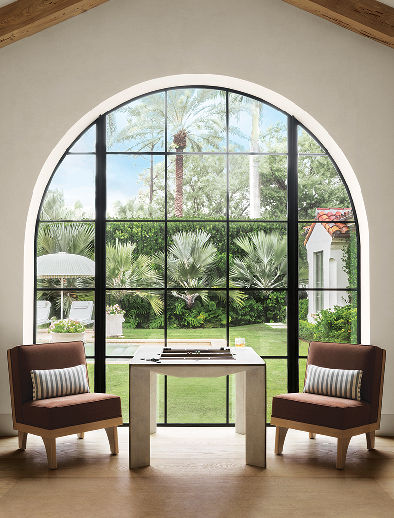 Next to the game room’s soaring window, Line lounge chairs by Michael van Beuren flank a shagreen Parsons game table by R&Y Augousti.