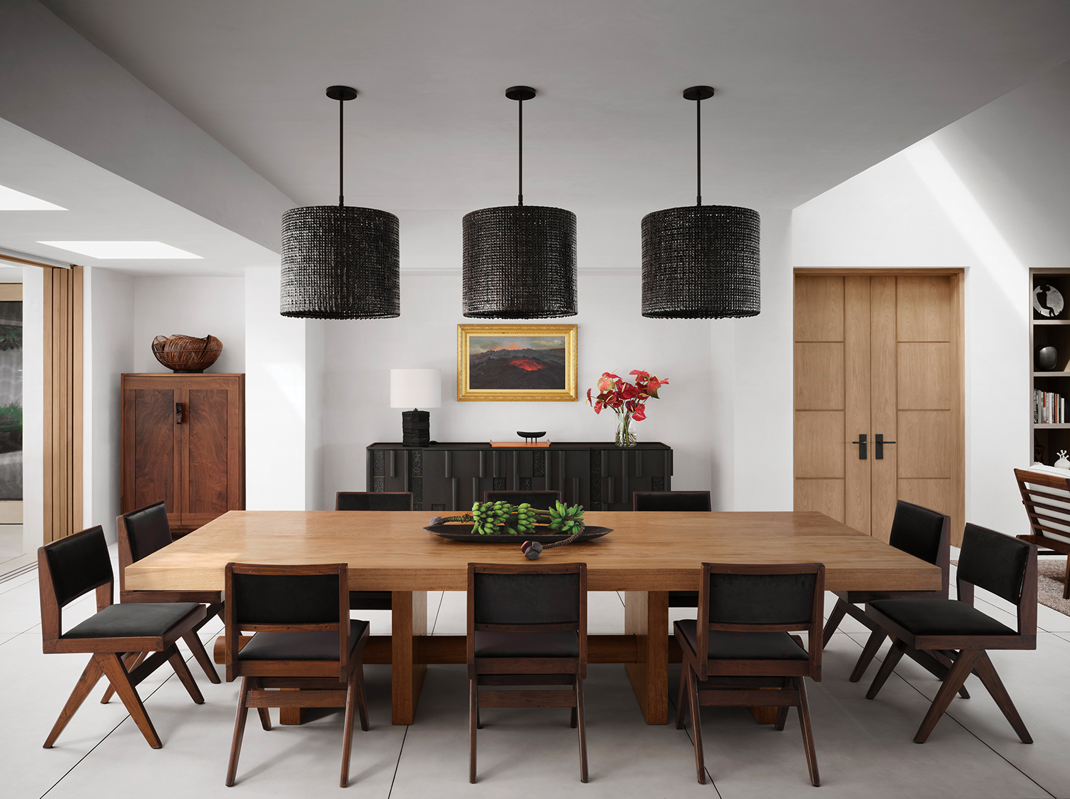 In the dining area, Hollis installed Scott Daniel pendants above a Jerome Abel Seguin table from Ralph Pucci and vintage Pierre Jeanneret chairs. Storage is provided by a George Nakashima cabinet and a Bruno Moinard Éditions sideboard, the latter surmounted by a D. Howard Hitchcock painting of a volcano from 1894.