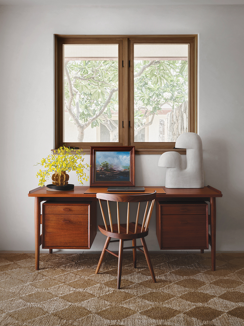 In a guest room, an Elisa Uberti lamp for Stahl + Band stands on a vintage Arne Vodder desk; the Nakashima chair is from Design Within Reach.