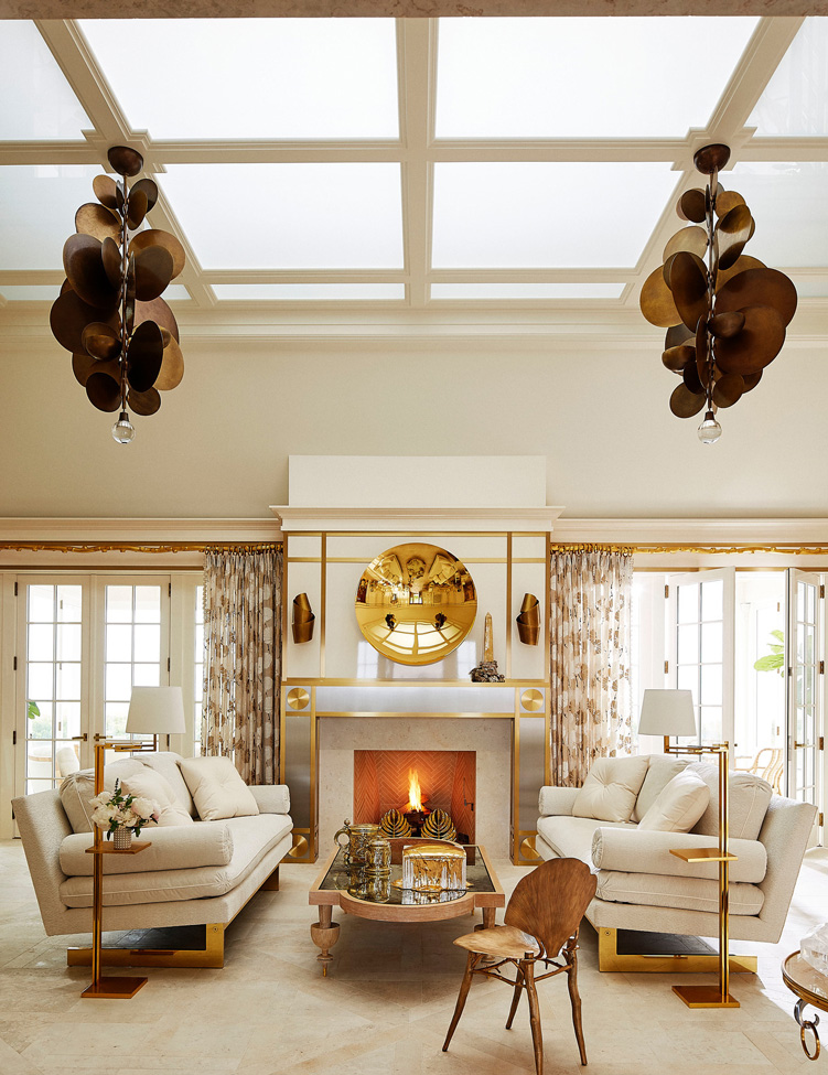 In the living room, an Anish Kapoor sculpture hovers above a custom chimney piece. The pendants are by Hervé Vander Straeten, and the curtains are of a Fabricutvoile. The walnut and mirror coffee table is from Lamberty. The custom sofas were designed by Alex Papachristidis and the Ginkgo chair is by Claude Lalanne.