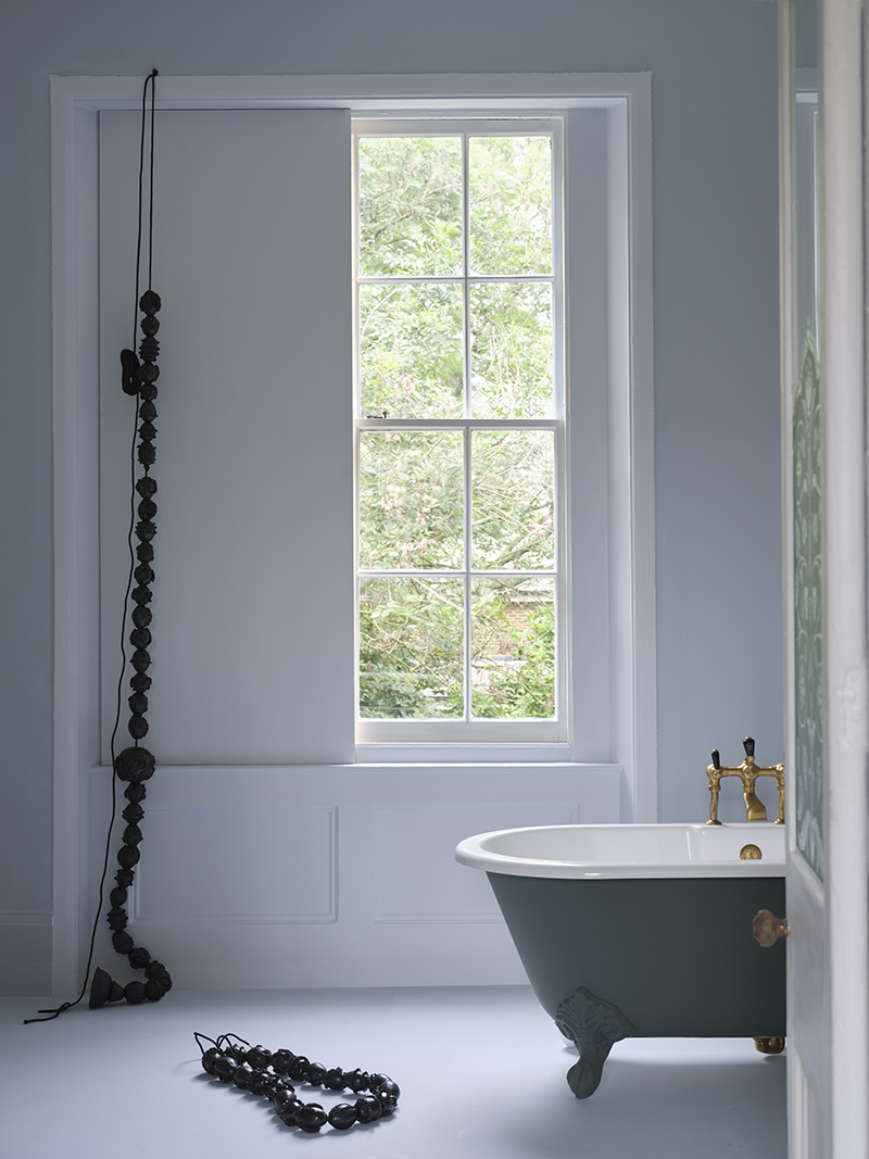 Walls painted Kakelugn No.317, window and shutter in Sizing No.314, and a bath coated in Douter No.318 by Farrow & Ball.