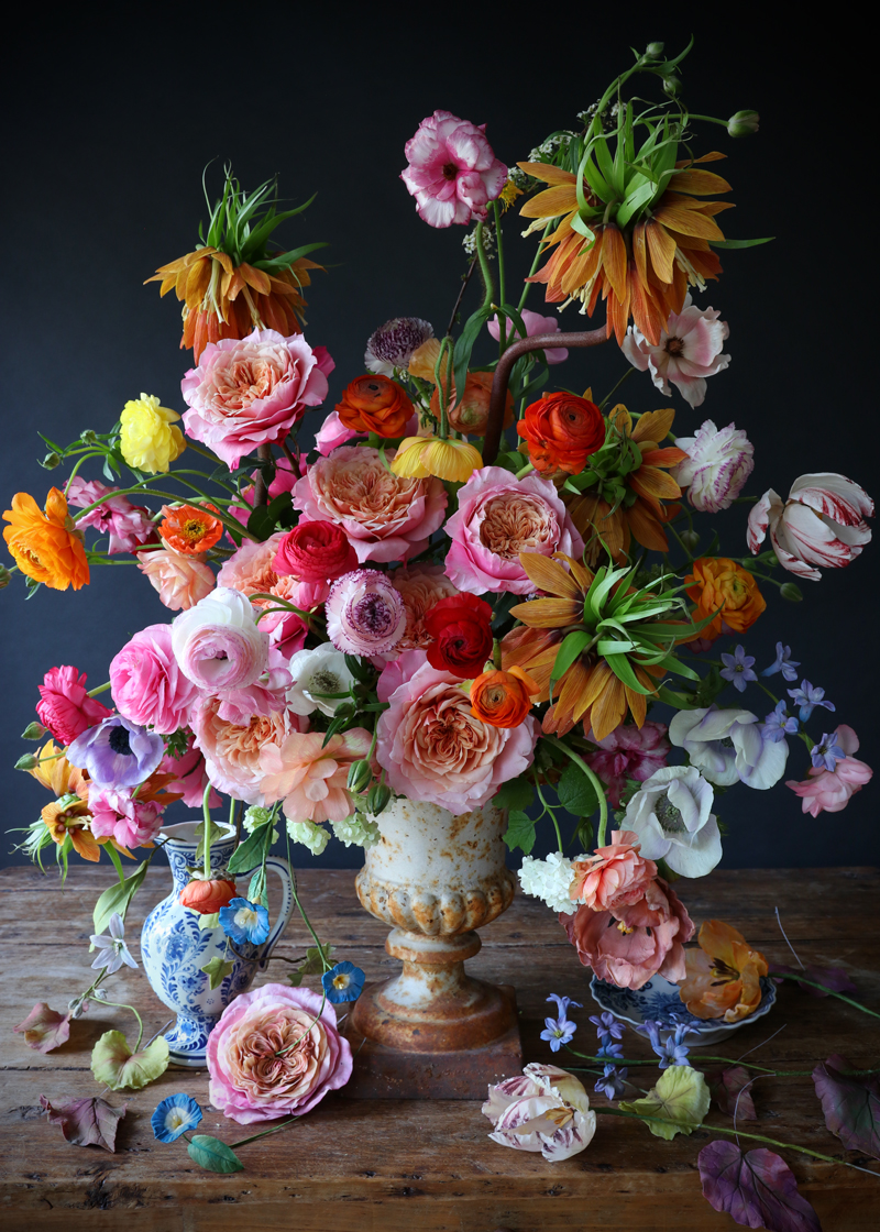 A spring arrangement of fresh and sugar flowers in urn vase.