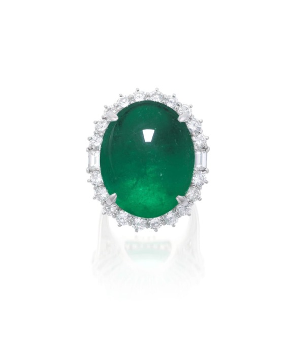 Emerald ring with diamond halo set in white gold, showcasing an oval-shaped green gem surrounded by sparkling accents.