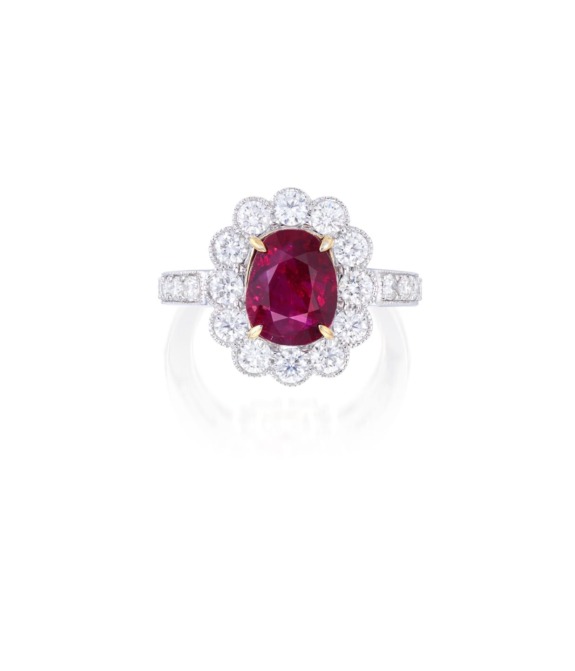 Elegant ruby ring with a diamond halo setting on a white background