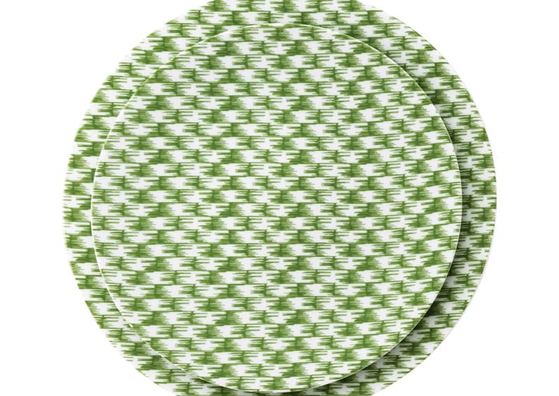 Two stacked dinner plates with a green and white houndstooth pattern on a plain white background.