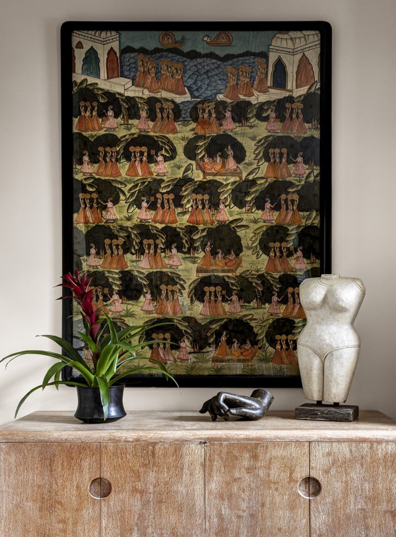Above a 1940s cerused oak sideboard hangs a 19th-century Pichawai, an Indian painting on cloth.