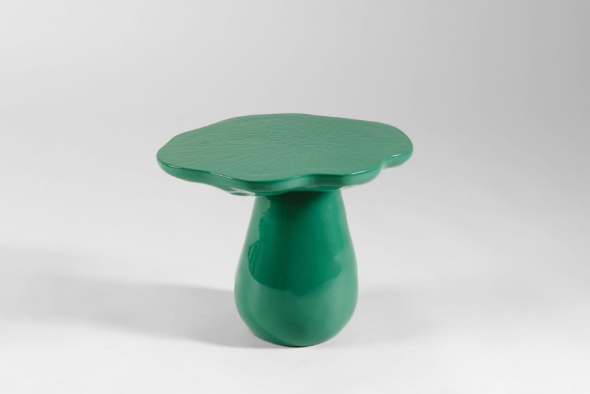 Green mushroom-shaped ceramic table with a glossy finish on a plain white background.