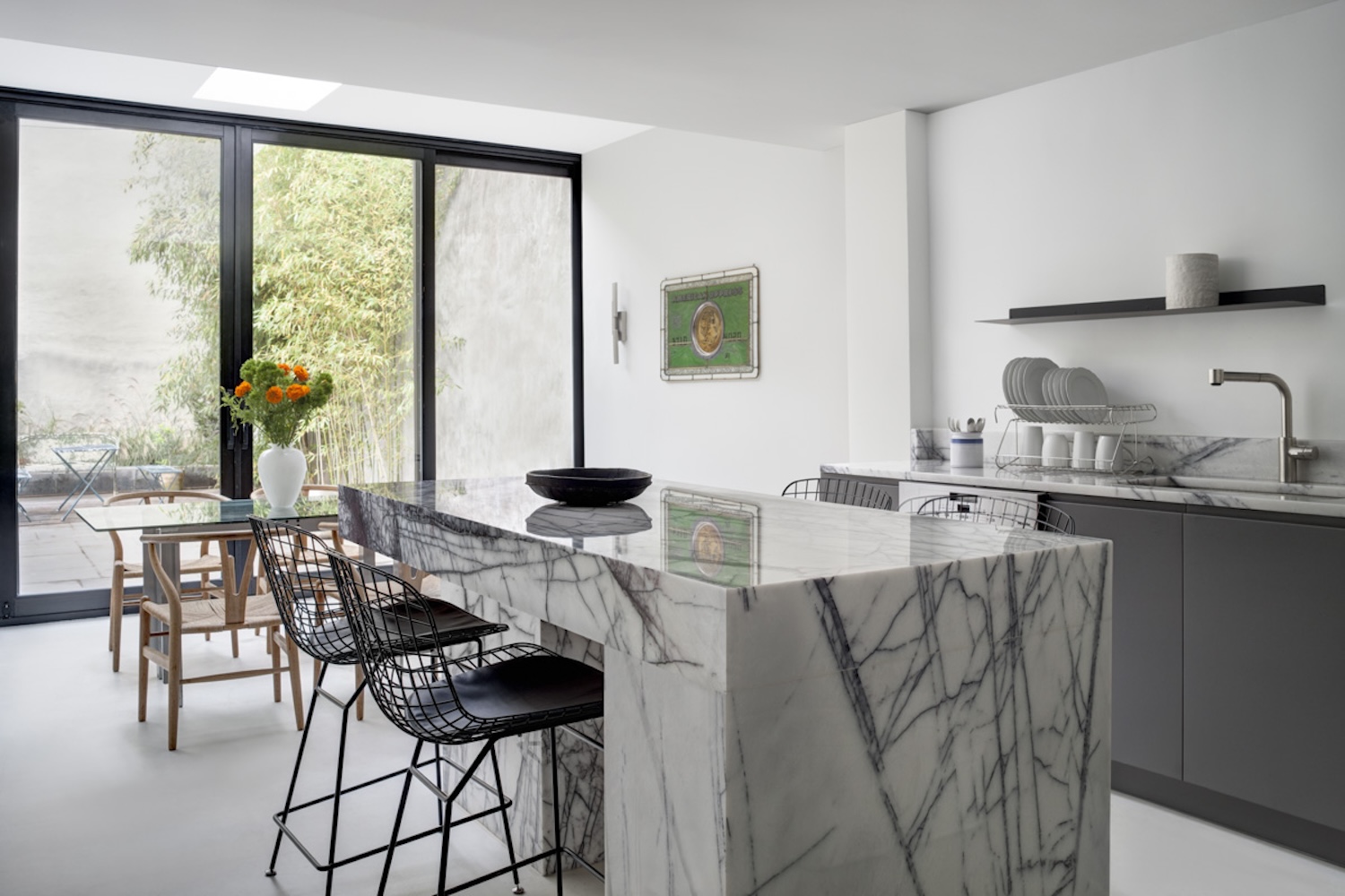 The kitchen’s dark gray cabinets feature integrated handles and the stainless steel appliances are from Miele and Fisher Paykel.