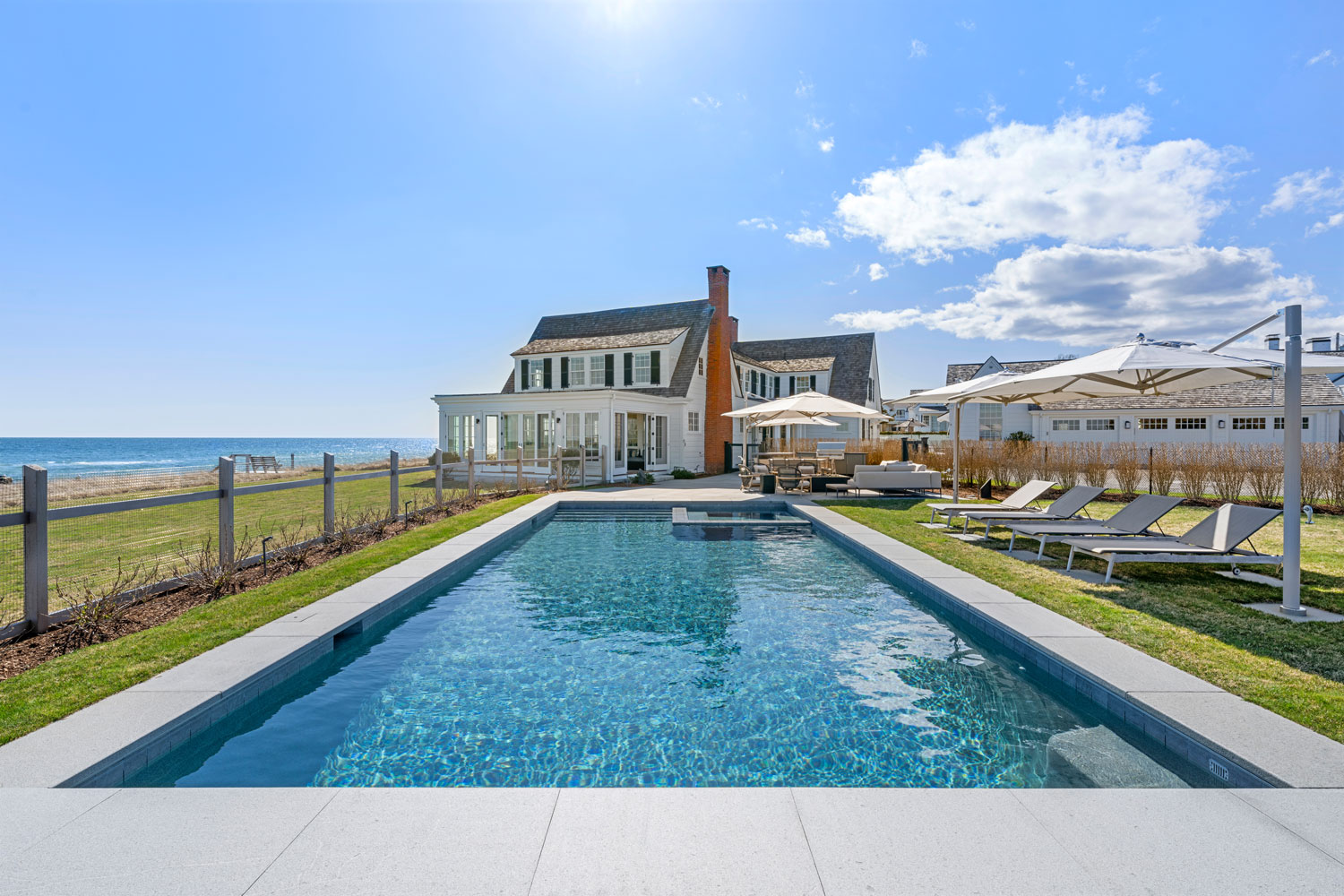 Outdoors, the home features a private beach, a built-in fire pit, and a resort-style pool.